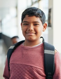 Smiling Student wearing backpack in school hallway